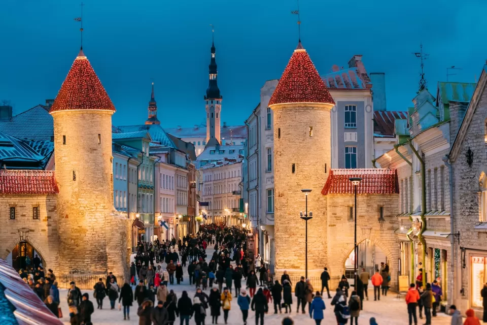 Crowd of people walking around Viru Gate medieval towers in Tallinn, Estonia.